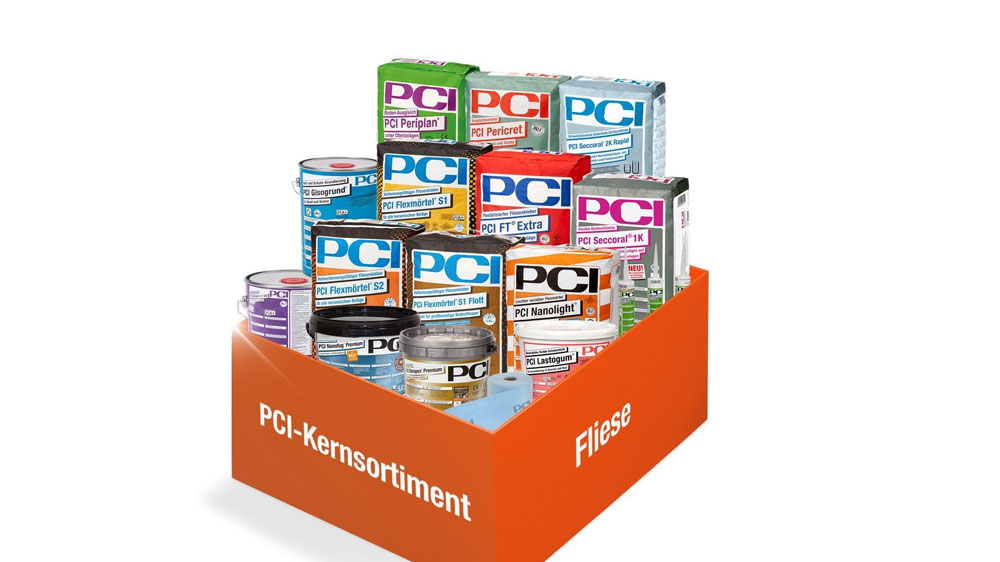 Präsentation des PCI-Kernsortiments für die Fliesenverlegung. Die Auswahl umfasst verschiedene Produkte wie Flexmörtel, Periplan Ausgleichsmasse, Pericret Reparaturmörtel, Nanolight Fliesenkleber, Lastogum Abdichtung und Secoral 2K Rapid. Das Sortiment ist in einer orangefarbenen Box mit der Beschriftung "PCI-Kernsortiment Fliese" arrangiert. Die Produkte decken alle Schritte von Grundierung über Abdichtung bis hin zur Verfugung ab, optimal für professionelle Fliesenarbeiten.