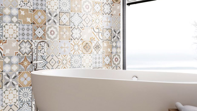 Wandfliesen mit farbenfrohen Retro-Mustern im Badezimmer, kombiniert mit einer freistehenden weißen Badewanne und Tageslicht durchflutetem Fenster. Die Fliesen schaffen eine stilvolle und lebendige Atmosphäre und eignen sich hervorragend für einzigartige Badgestaltungen.